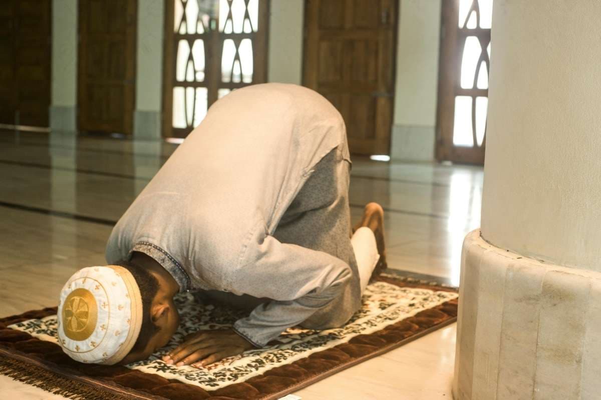 Musulman en prosternation sujud dans une mosquée symbolisant l'humilité et le repentir devant Allah