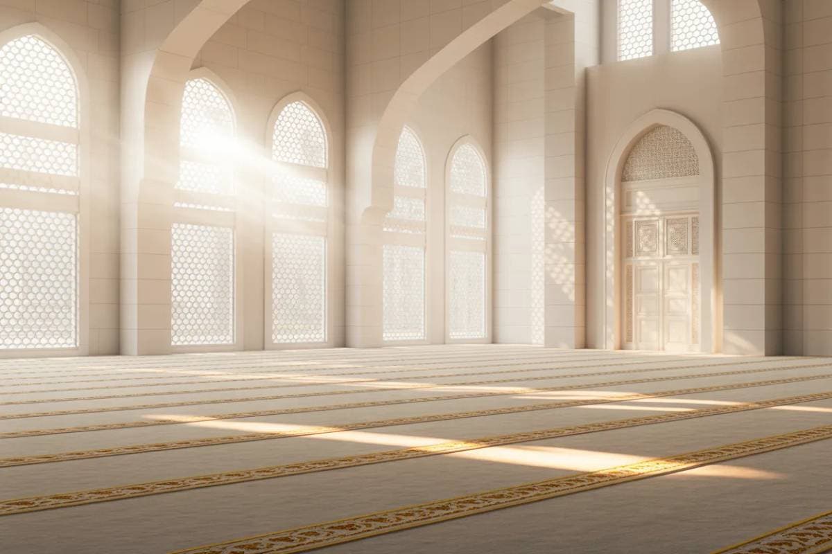 Salle de prière dans une mosquée avec arches et lumière illustrant le tarawih en islam